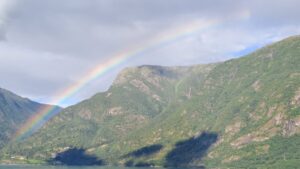 Rainbow over a mountain on top of a Fjord.